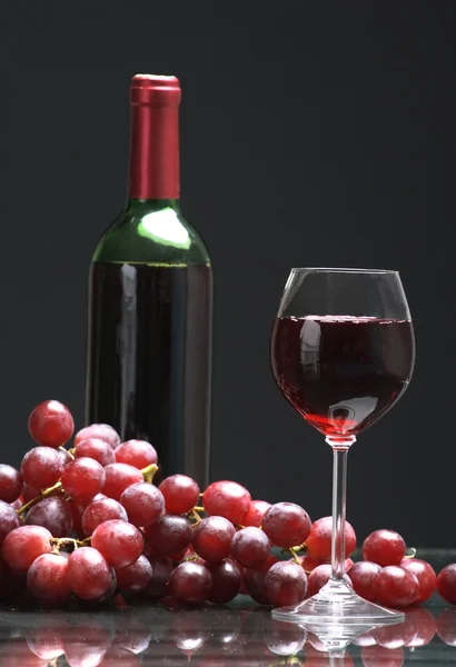 stock image Bottle and glass of wine, grapes