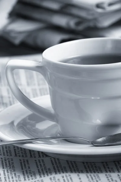 Café tasse sur un journal du matin nouvelles d'affaires — Photo