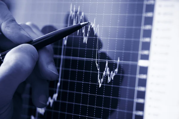 Mano del empresario mostrando diagrama en informe financiero con pluma — Foto de Stock