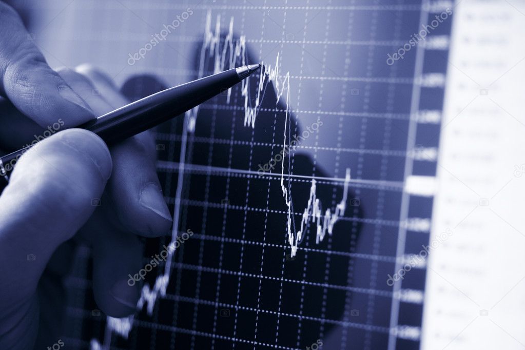 Businessman's hand showing diagram on financial report with pen