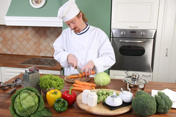 Young chef preparing lunch in kitchen — Stock Photo, Image