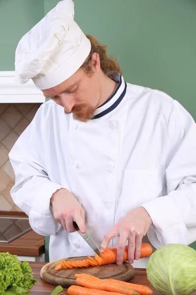 Young chef preparing lunch in kitchen — Stock Photo, Image