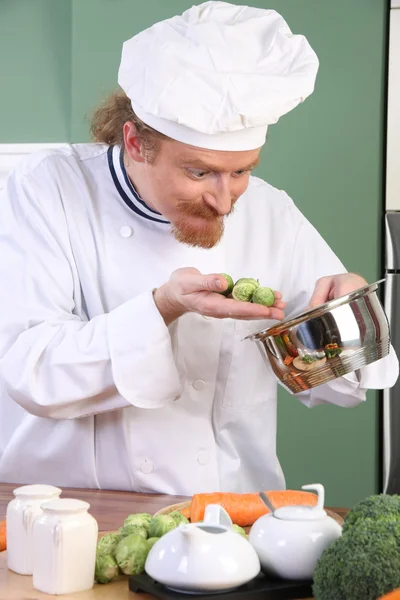 Забавный молодой шеф-повар с брюссельской капустой — стоковое фото