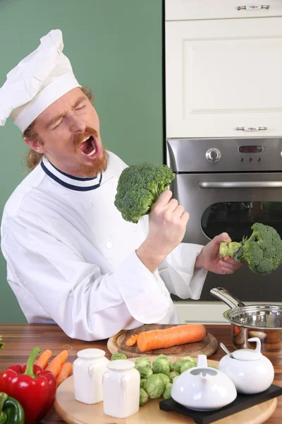 Lustiger junger Koch mit Brokkoli — Stockfoto
