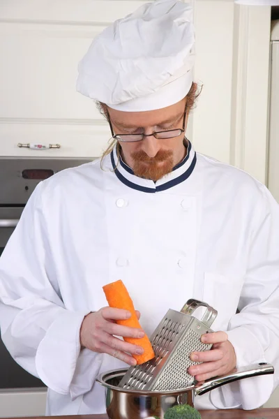 Young chef preparing lunch in kitchen — Stock Photo, Image