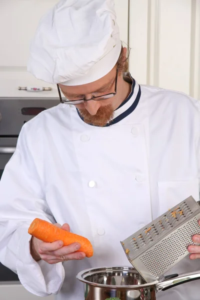 Jonge chef-kok voorbereiding lunch in keuken — Stockfoto