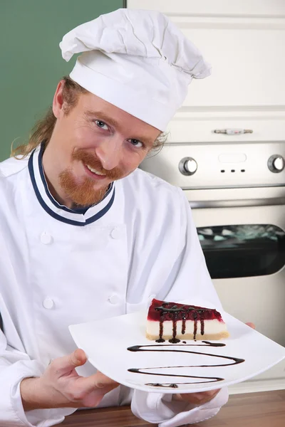 Jovem chef com pedaço de bolo — Fotografia de Stock