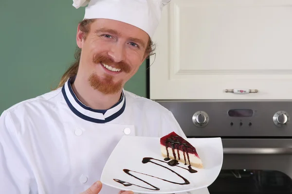 Jovem chef com pedaço de bolo — Fotografia de Stock
