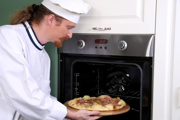 Jonge chef-kok bereid Italiaanse pizza in keuken — Stockfoto