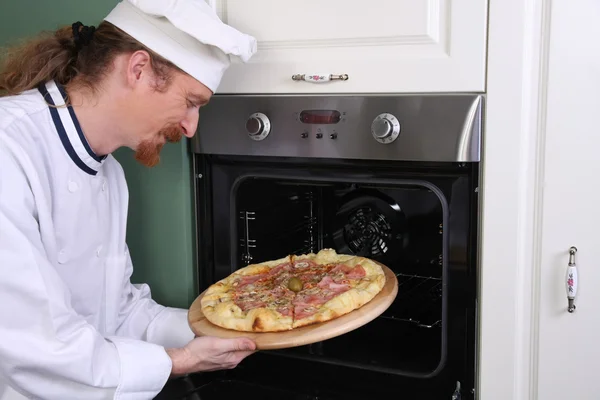 Jovem chef preparou pizza italiana na cozinha — Fotografia de Stock