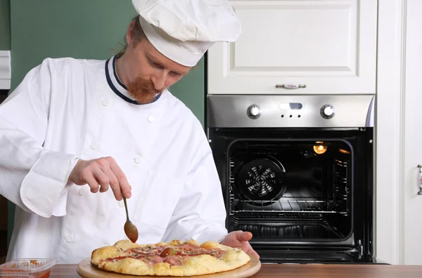 Junger Koch zubereitete italienische Pizza in der Küche — Stockfoto