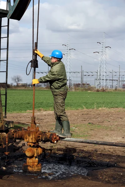 Нефтяники проверяют нефтяной насос — стоковое фото