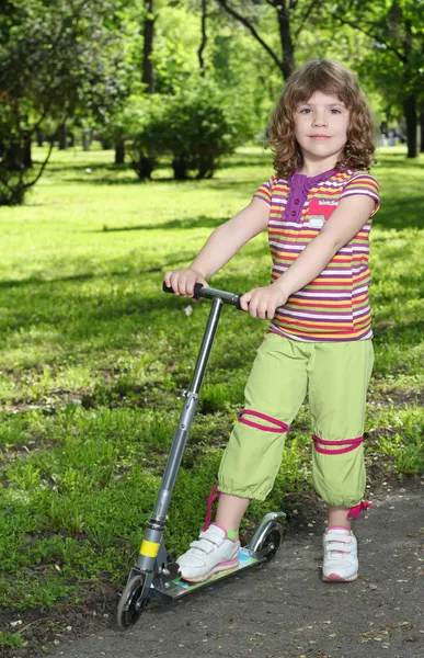 Beautiful little girl with scooter posing — Stock Photo, Image