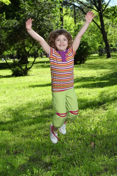 Happy little girl jumping in park — Stock Photo, Image