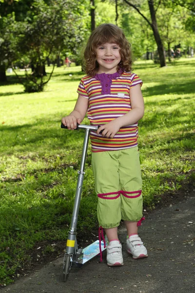 Happy little girl with scooter — Stock Photo, Image