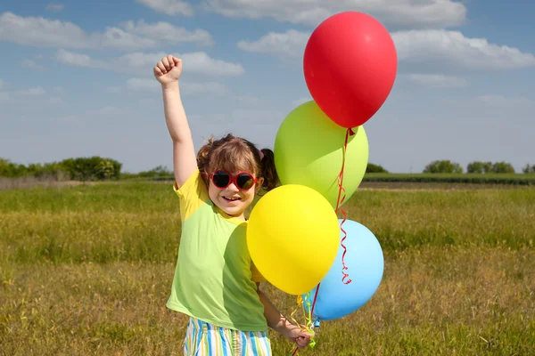 Gelukkig klein meisje met ballonnen — Stockfoto