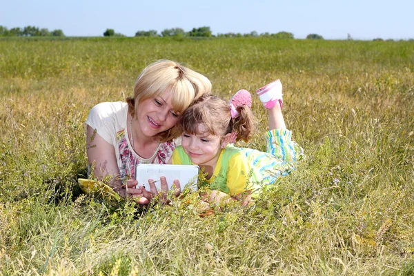 Madre e hija se están divirtiendo con la tableta —  Fotos de Stock