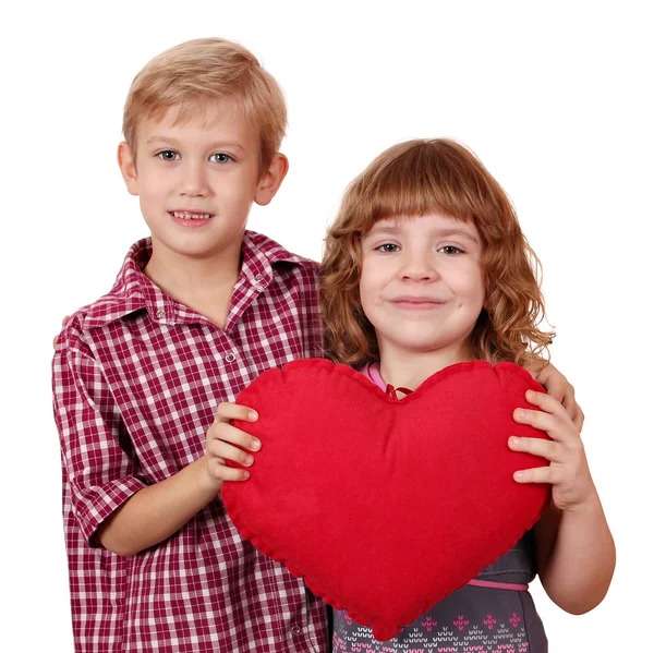 Маленькая девочка и мальчик позируют с красным сердцем — стоковое фото