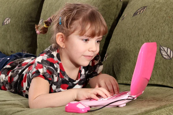Klein meisje typen op laptop — Stockfoto