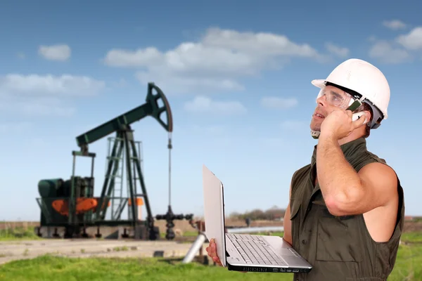 Operaio petrolifero con laptop e telefono — Foto Stock