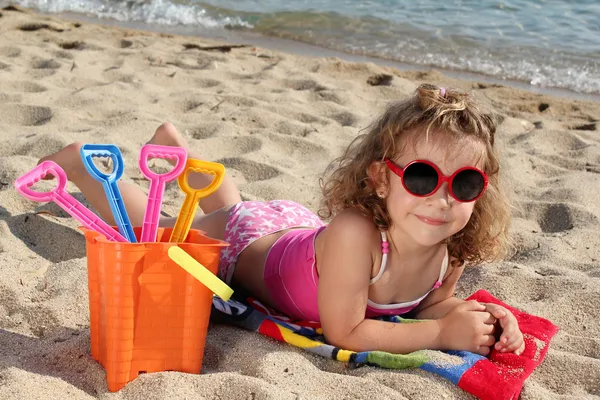 Liten flicka med solglasögon på stranden — Stockfoto