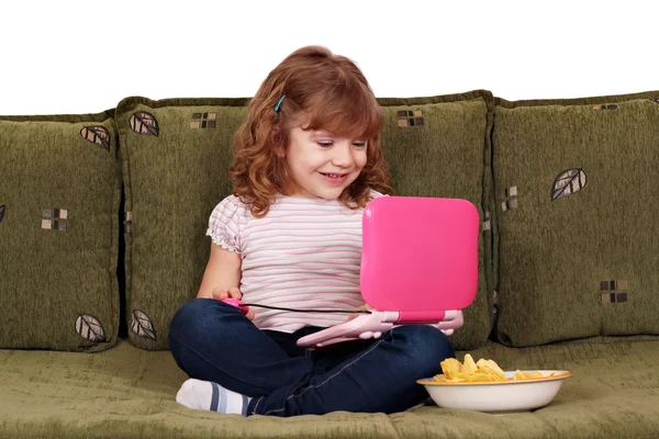 Malá dívka sedící na posteli s notebookem — Stock fotografie