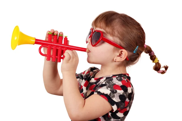 Malá holčička se slunečními brýlemi hrát trubku — Stock fotografie