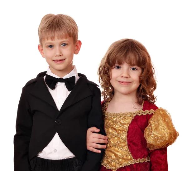 Boy in tuxedo and little girl in golden dress posing — Stock Photo, Image