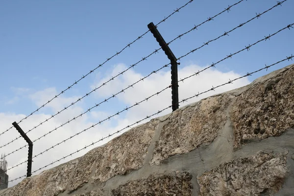 Barbed wire over the stone wall — Stock Photo, Image