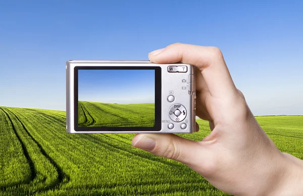 Digital camera in hand. Landscape Stock Picture
