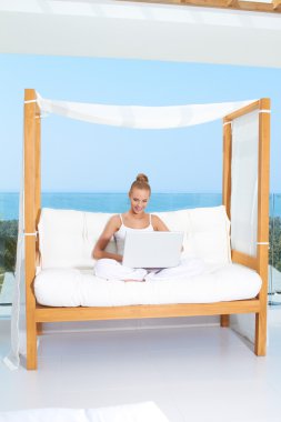 Woman on canopied seat with laptop clipart