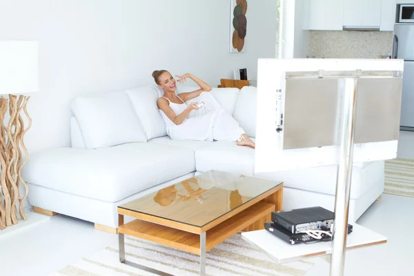 Mulher bonita assistindo tv em casa interior — Fotografia de Stock