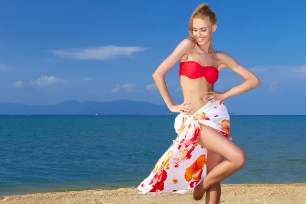 Очаровательная женщина стоит на тропическом пляже — стоковое фото