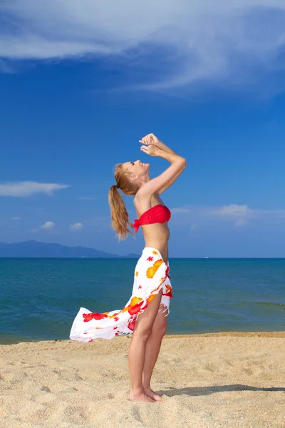 Mujer alegre con los brazos levantados en la playa — Foto de Stock
