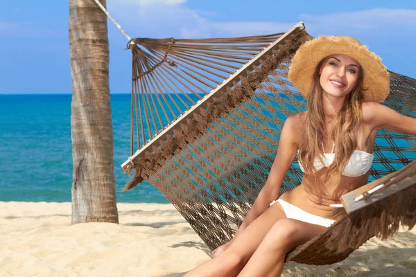 Улыбающаяся женщина в шляпе на прекрасном пляже — стоковое фото
