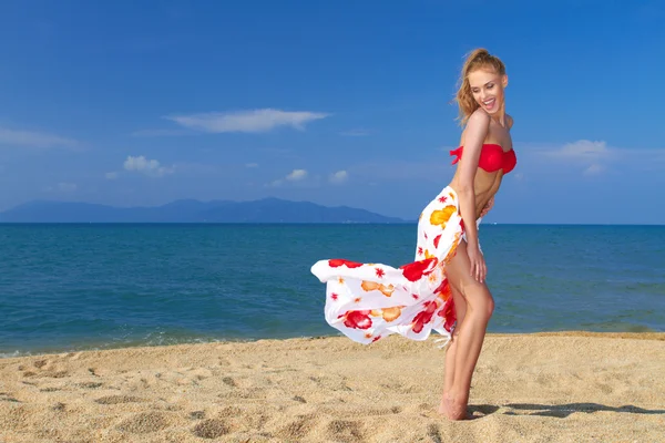 Lekfull stund med en söt blondin på stranden — Stockfoto