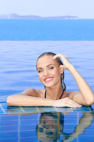 Femme souriante reflétée dans la piscine — Photo