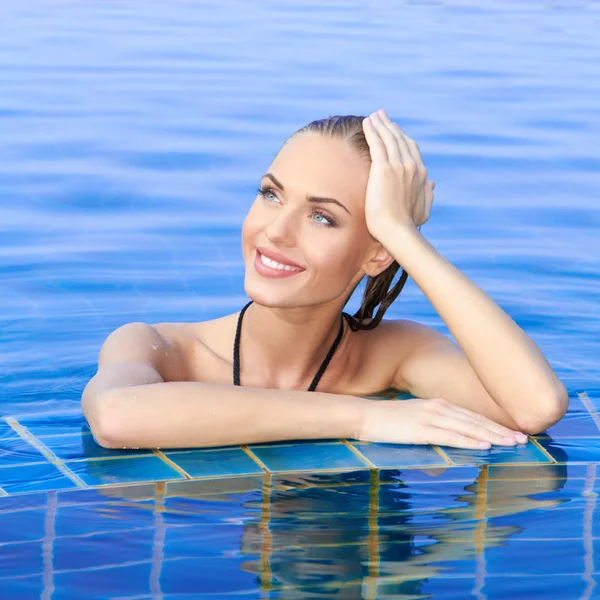 Mujer sonriente reflejada en la piscina — Foto de Stock