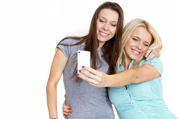Duas mulheres bonitas tirando foto de um telefone inteligente — Fotografia de Stock