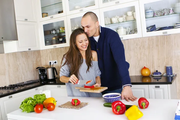 Portrett av et smilende par som lager mat sammen hjemme – stockfoto