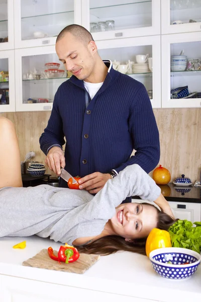 Portrett av et smilende par som lager mat sammen hjemme – stockfoto