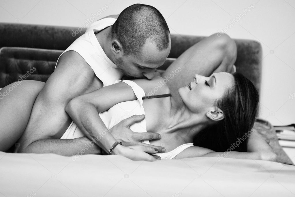 Young smiling couple looking at each other while lying in bed. B