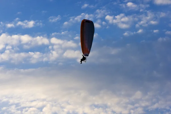 Duidelijke blauwe hemel met witte wolken en eenzame paraglider. — Stockfoto