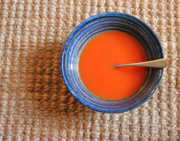 Cuenco de sopa azul con sopa de tomate rojo y una cuchara —  Fotos de Stock