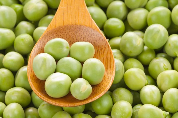 Fresh grren peas on wooden spoon — Stock Photo, Image