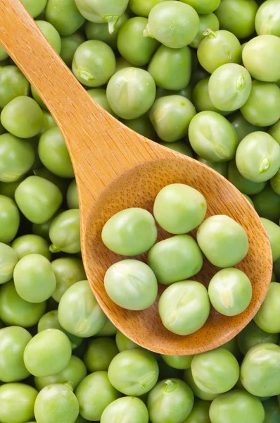 Fresh grren peas on wooden spoon — Stock Photo, Image