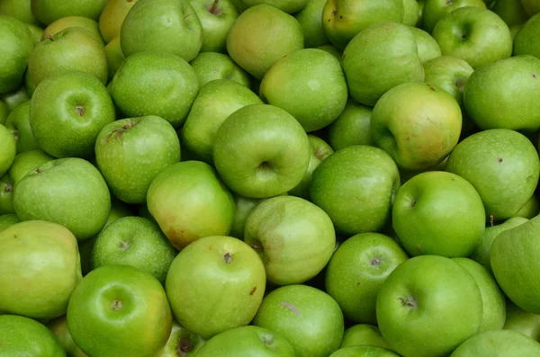 Close up of green apples on market stand — Stock Photo, Image