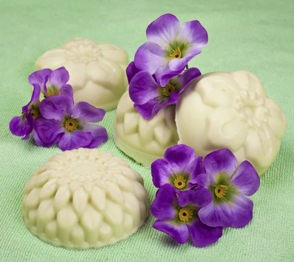 Ręcznie robione mydło na zielonym tle z kwiatami — Zdjęcie stockowe