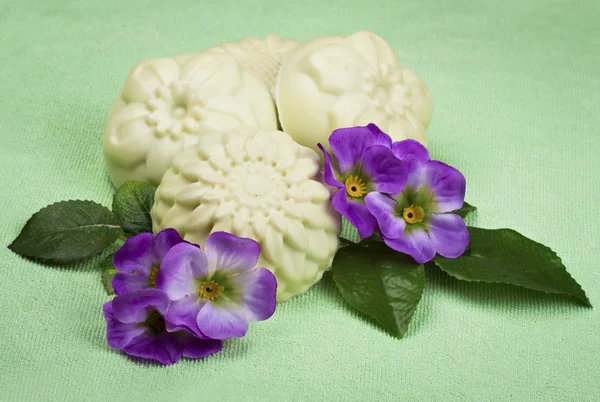 Handmade soap on a green background with flowers — Stock Photo, Image
