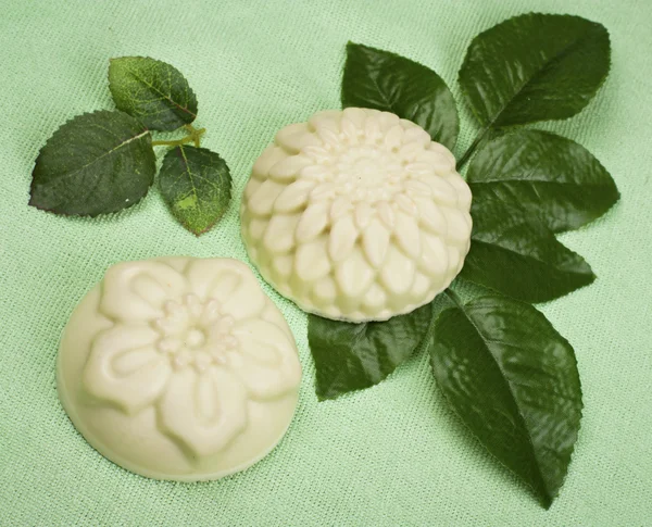Handmade soap on a green background with leaves of roses — Stock Photo, Image